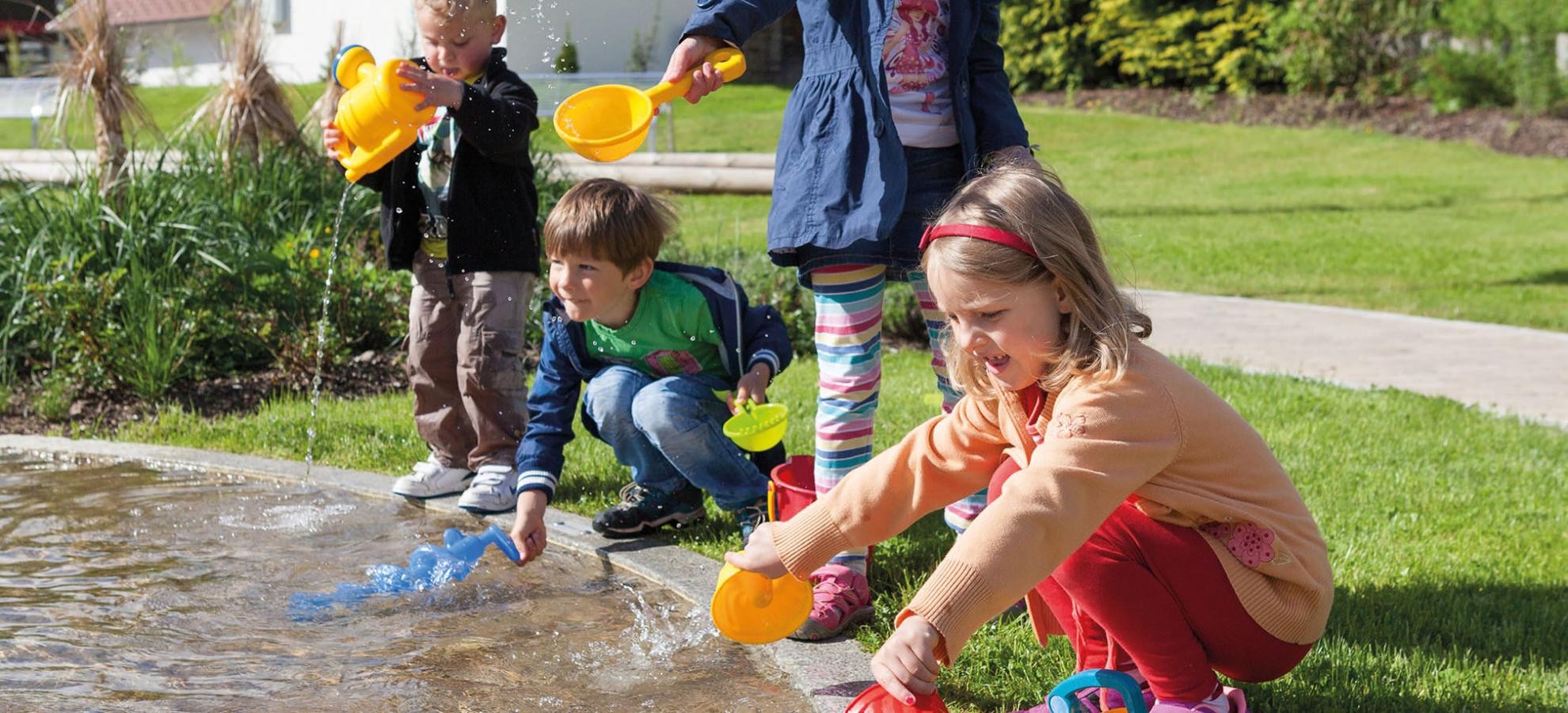 Spielende Kinder in der Ortsmitte am Wasserlauf Spielende Kinder in der Ortsmitte am Wasserlauf